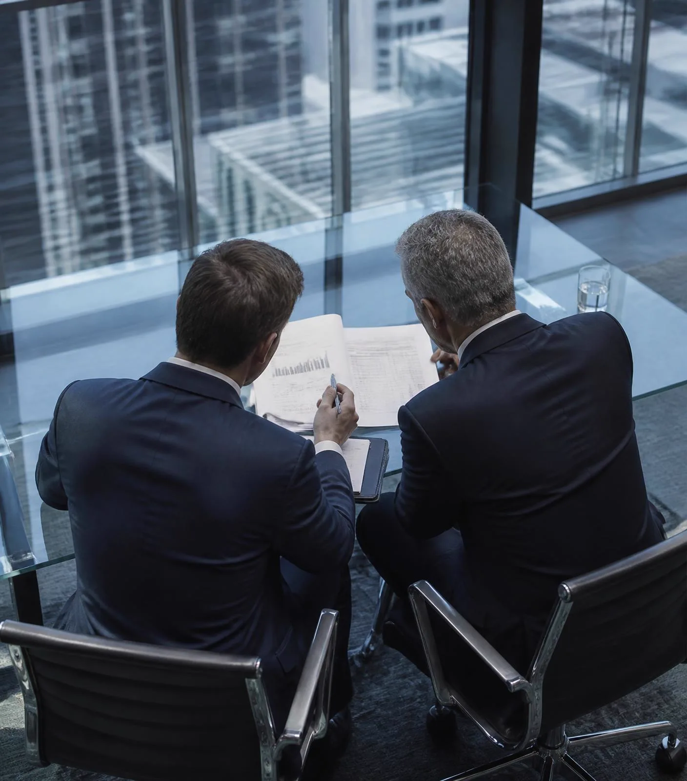 Two executives reviewing financial reporting in a modern boardroom