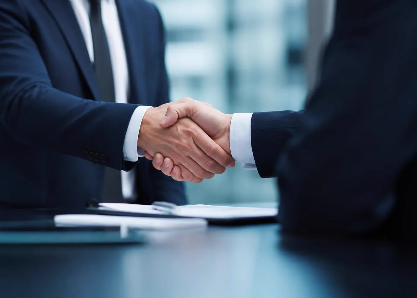 Executives shaking hands after closing an enterprise agreement